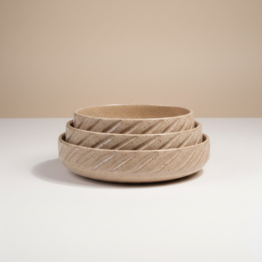Set of three woven baskets on a white surface with a beige background