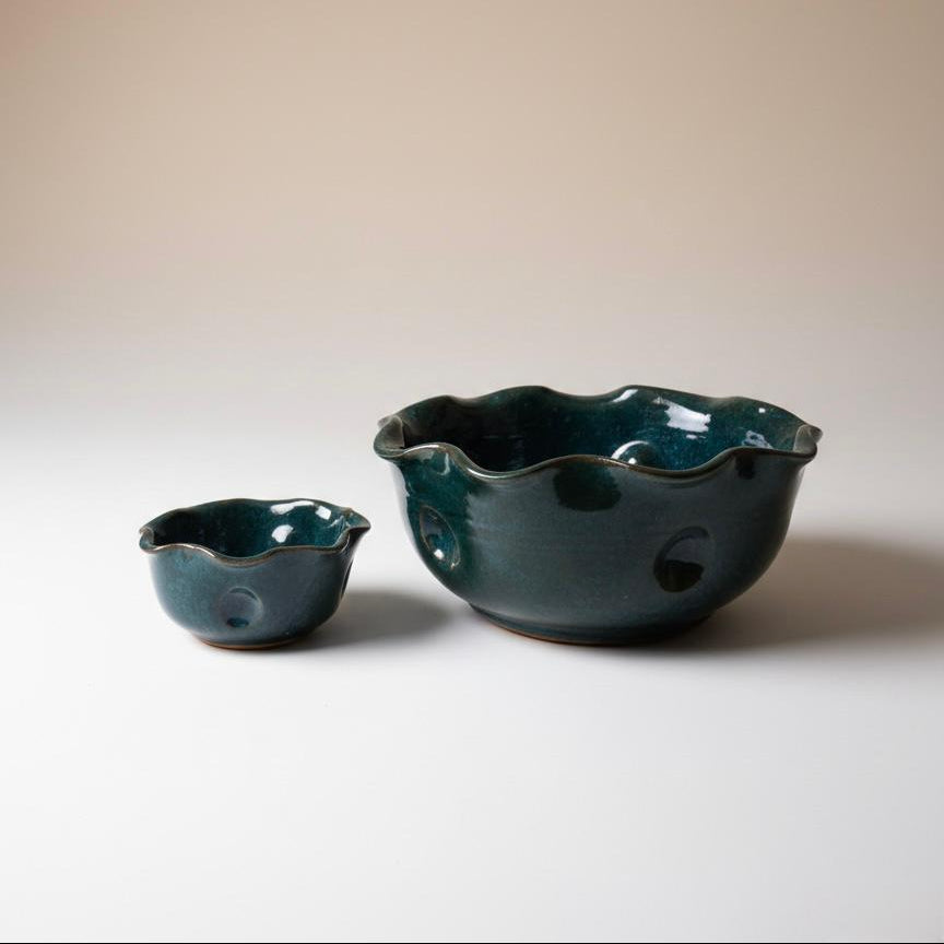 Two green ceramic bowls on a plain background