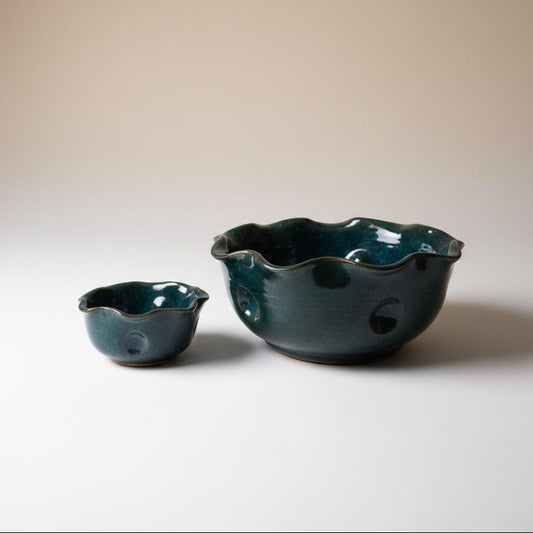 Two green ceramic bowls on a plain background